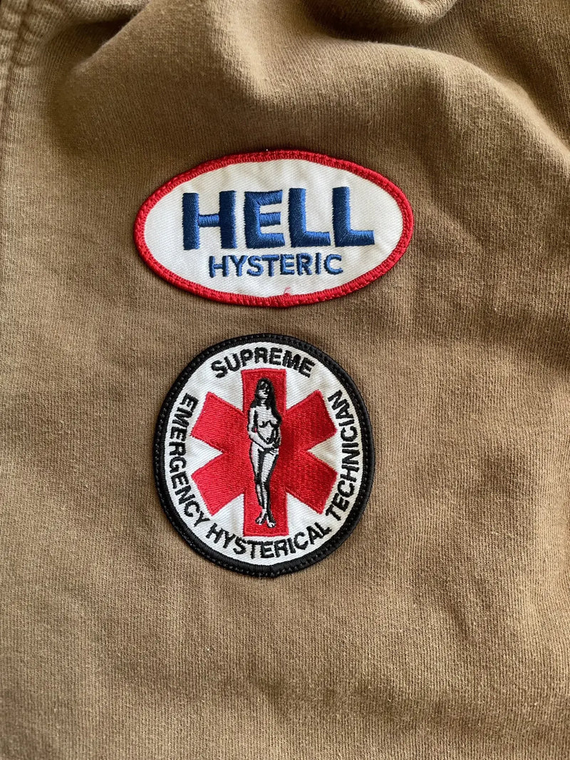 Two patches on a beige background, one with 'HELL HYSTERIC' and the other with 'Supreme Emergency Hysterical Technician'.