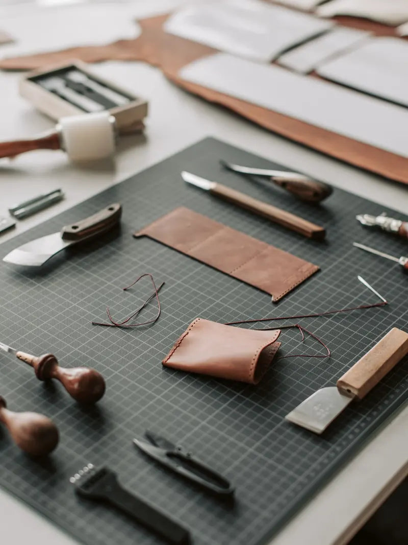 Leatherworking tools laid out on the cutting bench