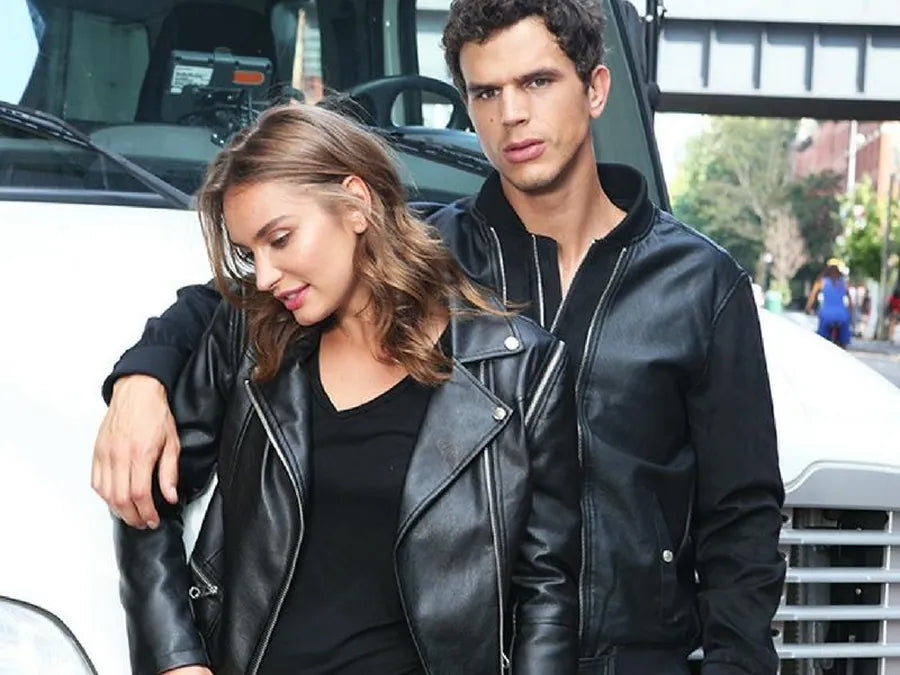 Two models in black leather biker and bomber jackets on a city street